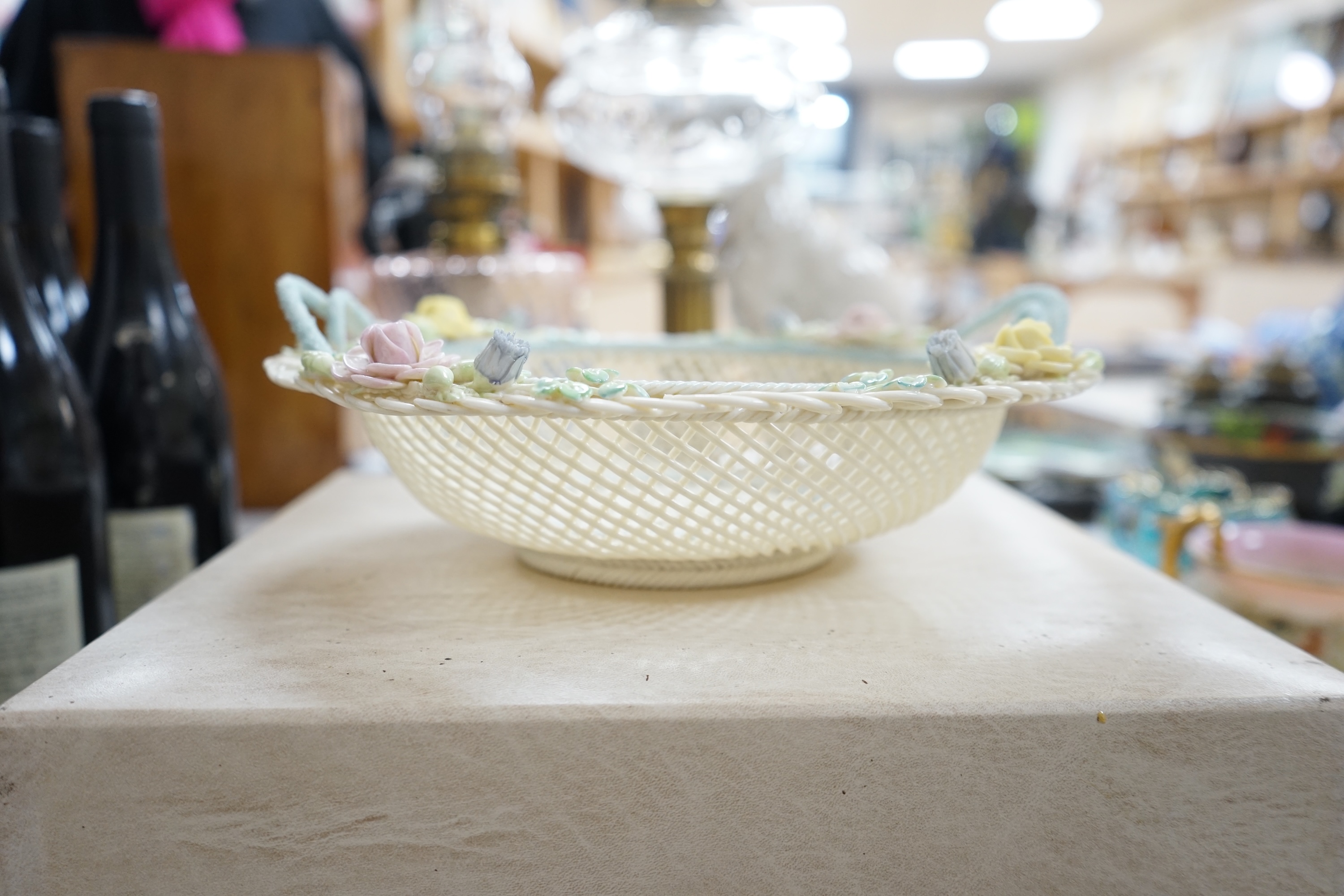 A boxed Belleek coloured basket, 28cm diameter. Condition - fair to good, some damage and wear to the box.